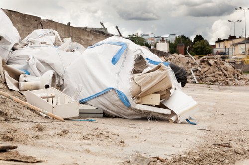 Front view of a skip hire vehicle and skips at a depot